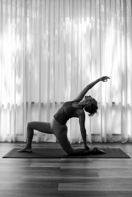 Laurence in a low lunge side stretch, black and white